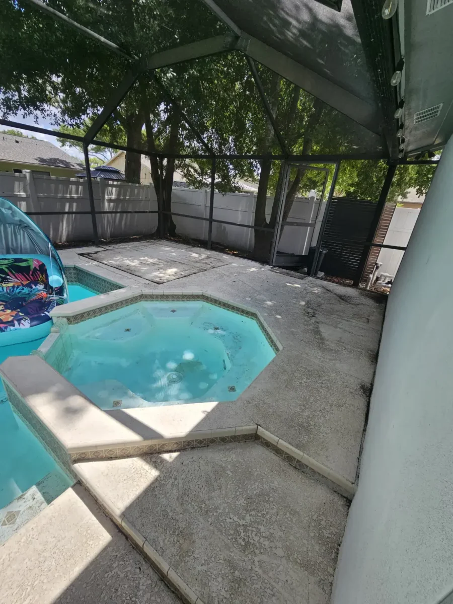 Let Us Restore Your Outdoor Living Space Outdoor screened patio area with a small octagonal spa connected to a swimming pool surrounded by textured concrete flooring